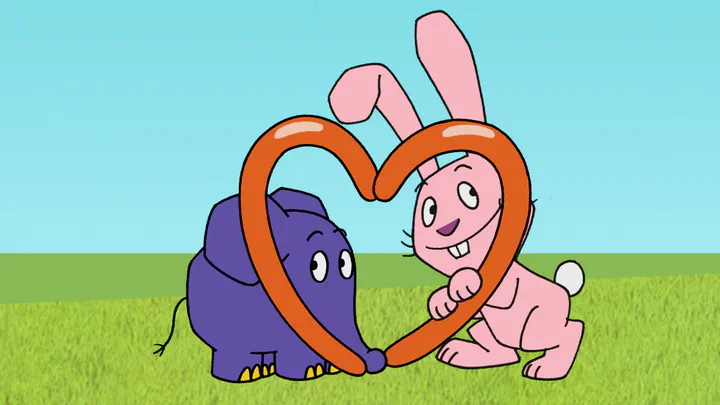 Elephant and rabbit looking through heart formed from a modeling balloon
